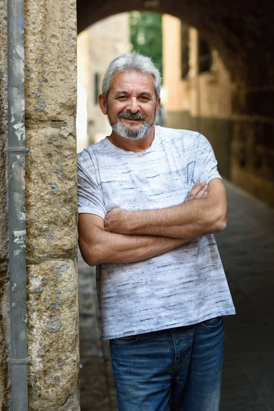 Olgun adam kamera kentsel arka planda bakarak gülen