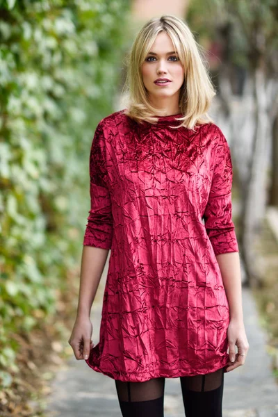 Beautiful young blonde woman in green leaves background — Stock Photo, Image