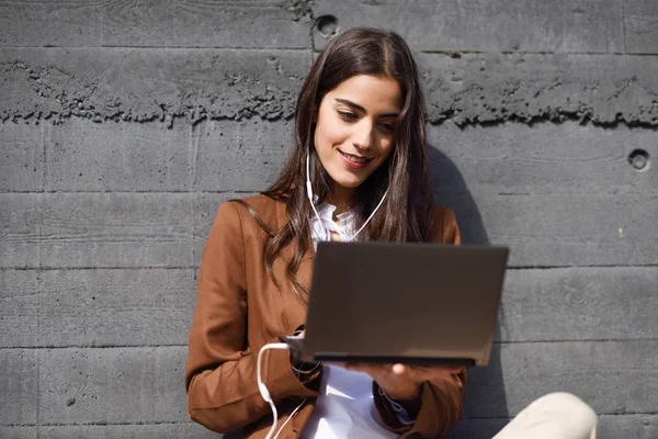 Jovem empresária sentada no chão olhando para seu laptop compu — Fotografia de Stock