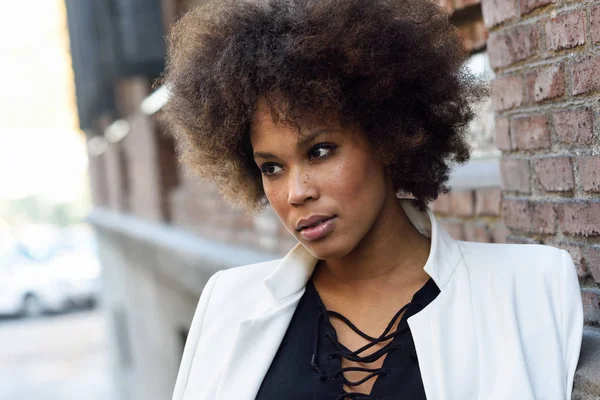 Ung svart kvinna med afro frisyr stående i urban backgrou — Stockfoto