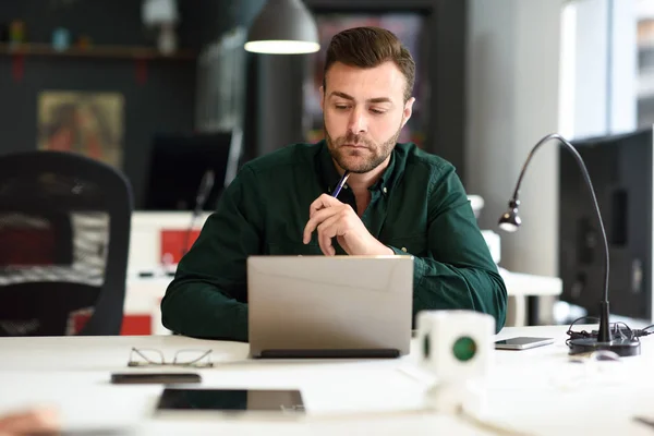 Hombre joven estudiando con ordenador portátil en escritorio blanco . —  Fotos de Stock