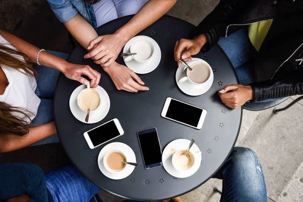 Manos con tazas de café y smartphones en un café urbano . — Foto de Stock
