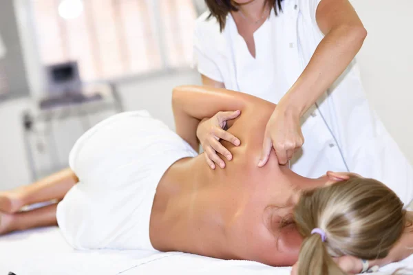 Profissional fisioterapeuta feminino dando massagem no ombro para b — Fotografia de Stock