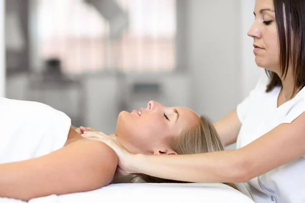 Mujer joven recibiendo un masaje en la cabeza en un centro de spa. —  Fotos de Stock
