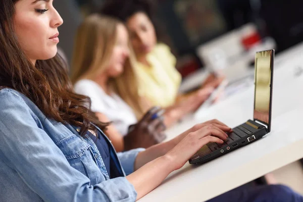 Giovane donna che studia con computer portatile su scrivania bianca . — Foto Stock