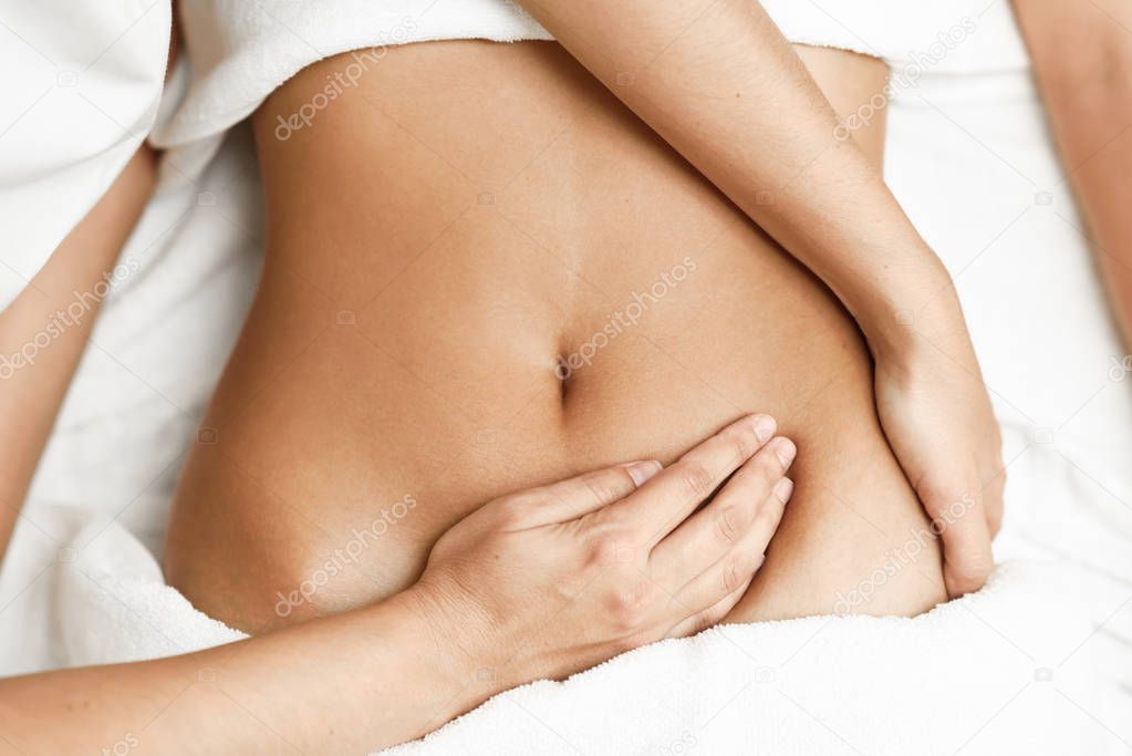 Hands massaging female abdomen.Therapist applying pressure on be