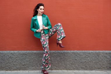 Kentsel arka planda gülümseyen genç esmer kadın.