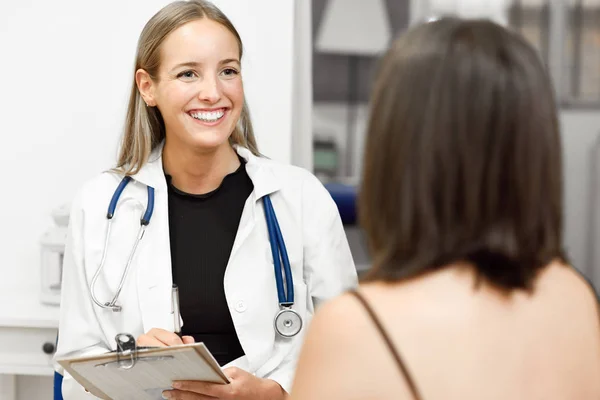 Female doctor explaining diagnosis to her young woman patient. — Stock Photo, Image