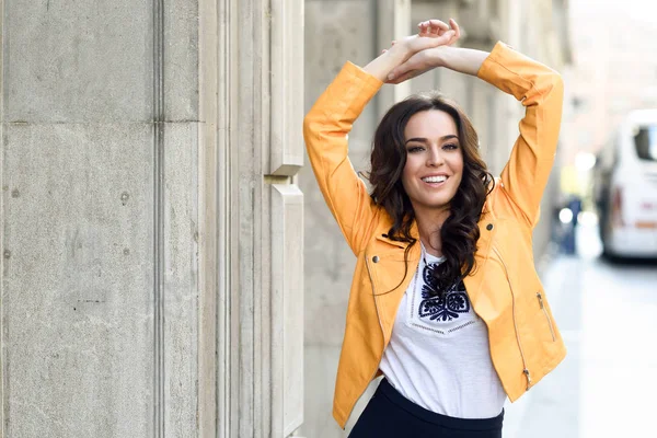 Young brunette woman smiling in urban background. — Stock Photo, Image