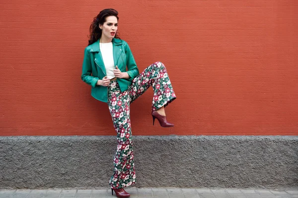 Kentsel arka planda gülümseyen genç esmer kadın.