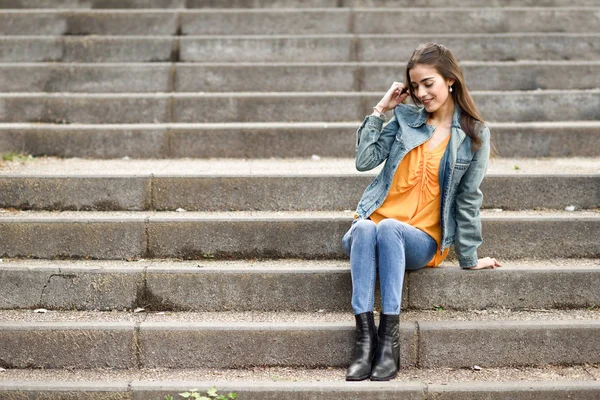 在城市的步骤中穿便服的头发很漂亮的女人. — 图库照片