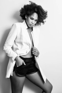 Genç siyah kadın afro saç modeli possing beyaz bir duvar yakınındaki