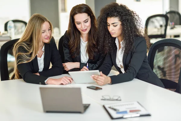 Tres empresarias trabajando juntas en una oficina moderna — Foto de Stock