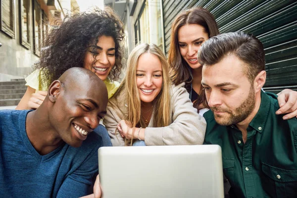 Multi-ethnic group of young people looking at a tablet computer — Stock Photo, Image