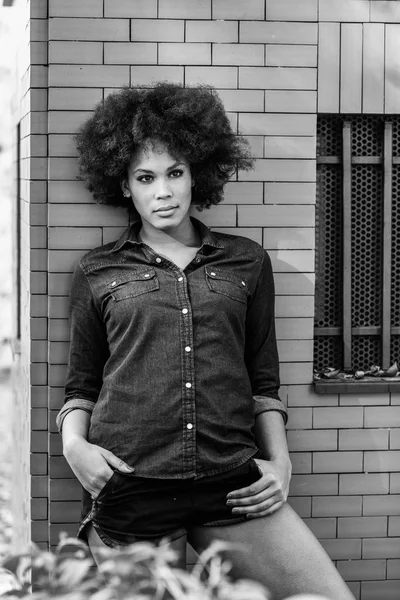 Junge schwarze Frau mit Afro-Frisur steht in urbaner Umgebung — Stockfoto