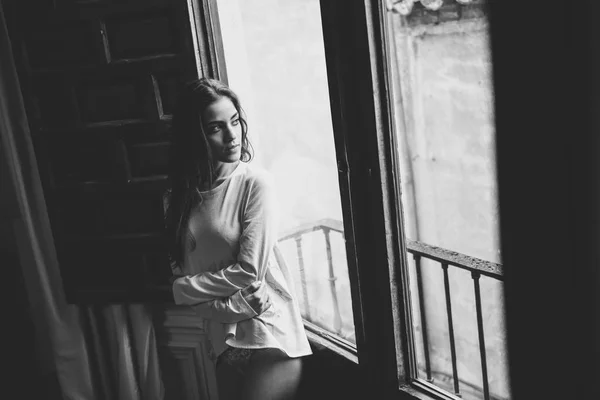 Woman in pyjama and white panties posing near a window — Stock Photo, Image