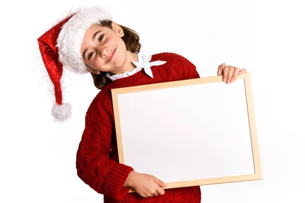 Little girl wearing santa hat holding blank board — Stock Photo, Image