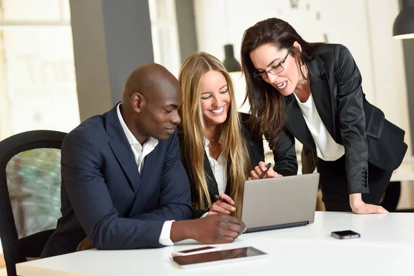 Multi-ethnic group of three businesspeople meeting in a modern o — Stock Photo, Image
