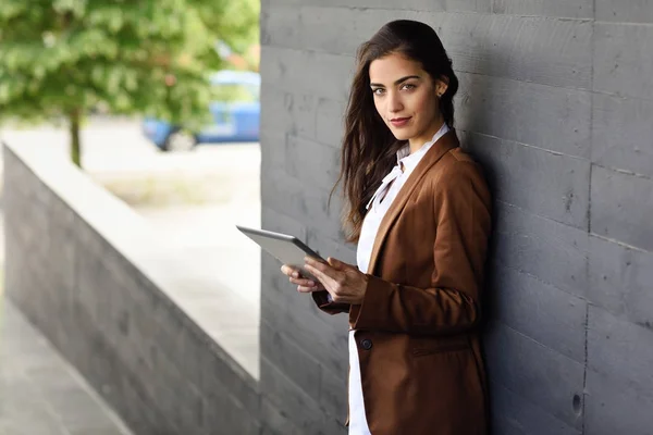 Businesswoman with tablet computer standing outside of an office — Stock Photo, Image