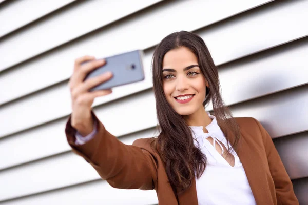 Young woman taking selfie photograph with smartphone in urban ba — Stock Photo, Image