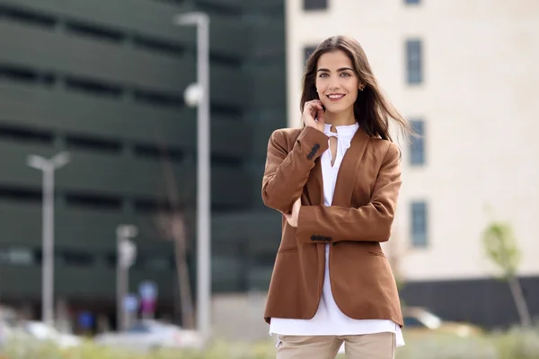 Mujer joven con el pelo bonito de pie fuera del edificio de oficinas . —  Fotos de Stock