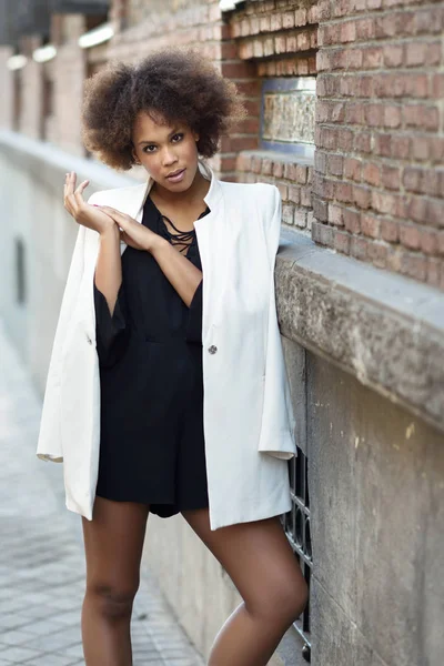 Joven mujer negra con peinado afro de pie en el fondo urbano — Foto de Stock