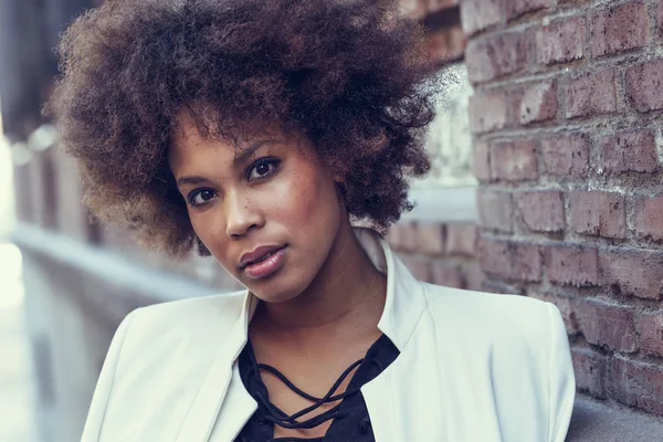Jovem mulher negra com penteado afro em pé no backgrou urbano — Fotografia de Stock