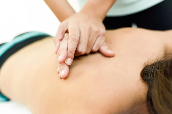 Young woman receiving a back massage in a spa center. — Stock Photo, Image