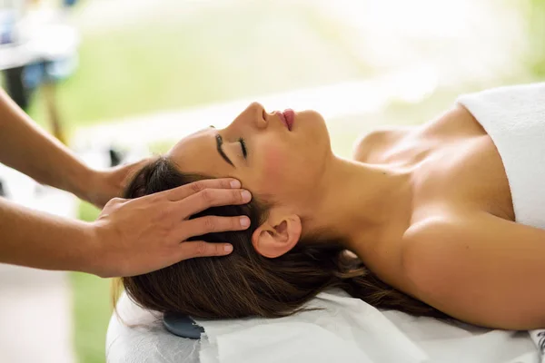 Jovem sorrindo mulher recebendo uma massagem na cabeça em um centro de spa . — Fotografia de Stock