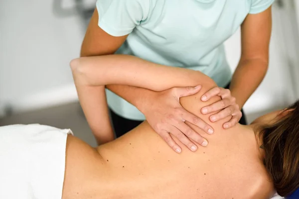 Professional female physiotherapist giving shoulder massage to a — Stock Photo, Image