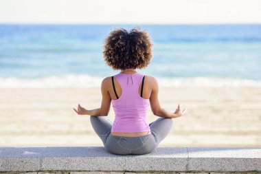 Siyah kadın, afro saç modeli, plaj Yoga yapıyor