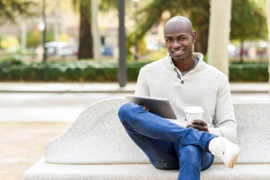 Tablet bilgisayar ile genç adam siyah ve kahve götürmek