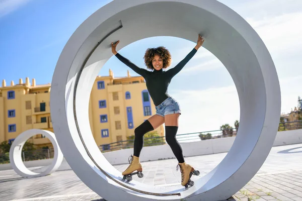 Mujer negra en patines de ruedas montando al aire libre en la calle urbana — Foto de Stock