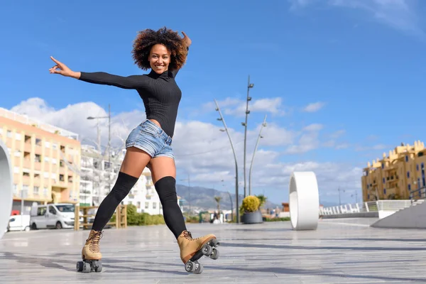 Mulher negra em patins andando ao ar livre na rua urbana — Fotografia de Stock