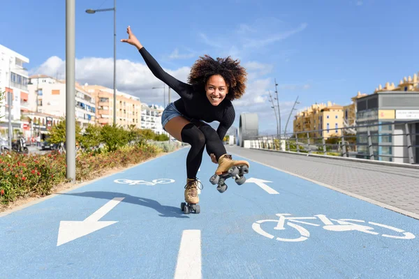 Donna nera sui pattini a rotelle in sella alla linea bici — Foto Stock