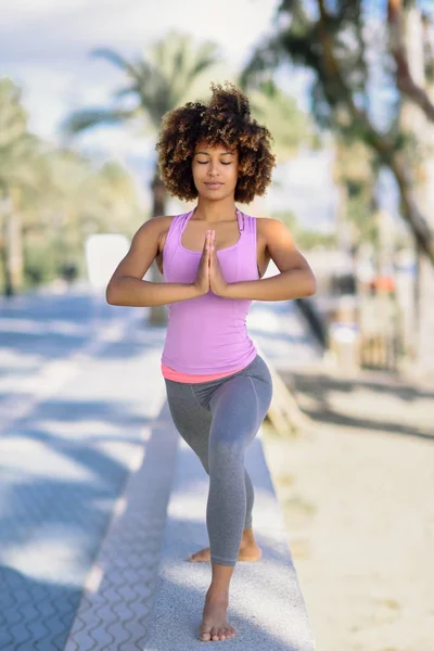 Zwarte vrouw, afro kapsel, doen yoga in het strand — Stockfoto