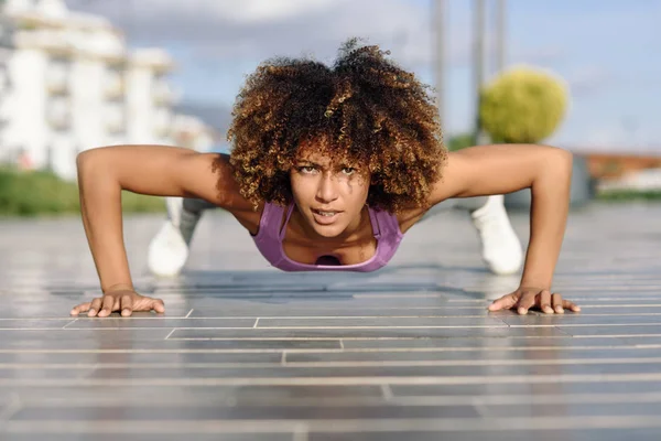 Preto ajuste mulher fazendo flexões no urbano chão . — Fotografia de Stock