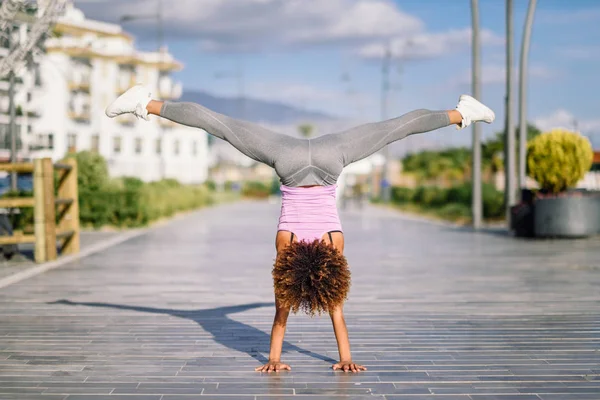 Preto ajuste mulher fazendo fitness acrobacias no urbano fundo — Fotografia de Stock