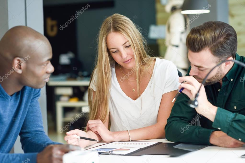 Multi-ethnic group of three young people studying together