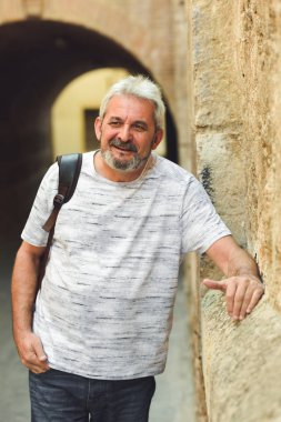 Olgun adam kentsel arka planda gülümseyen