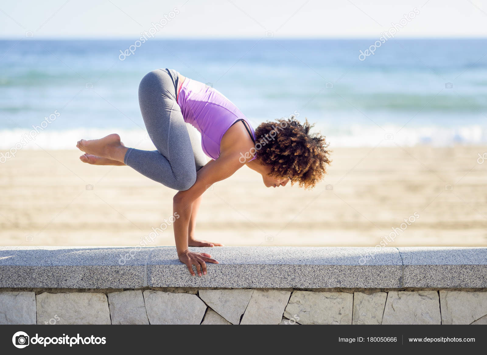 Black woman, afro hairstyle, doing yoga in the beach Stock Photo by  ©javiindy 180050666