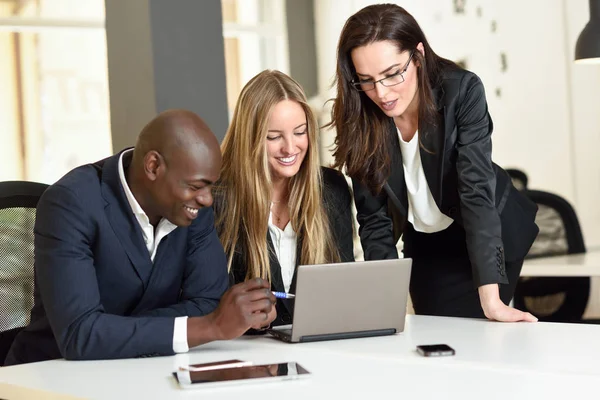 Multi-ethnic group of three businesspeople meeting in a modern o — Stock Photo, Image