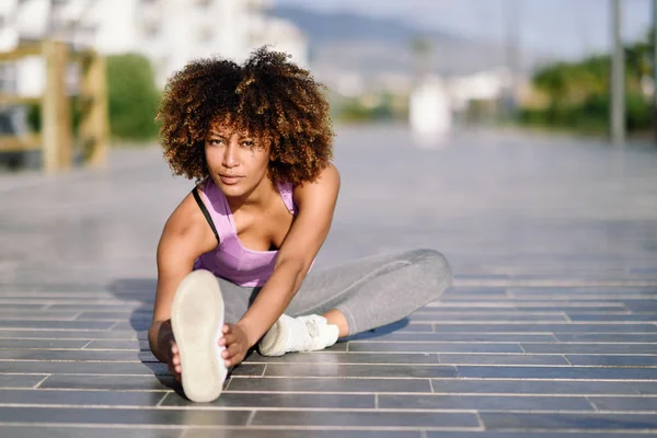 Jonge zwarte vrouw doen stretching na het uitvoeren van buitenshuis — Stockfoto