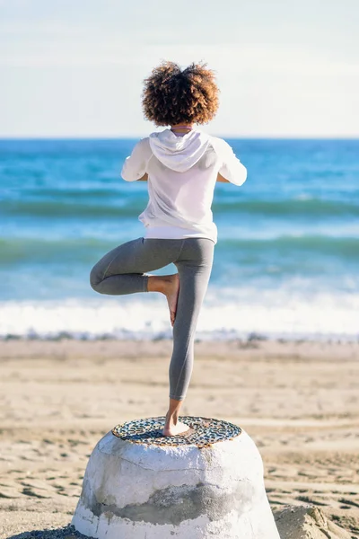 Widok z tyłu młody czarny kobieta robi joga na plaży — Zdjęcie stockowe