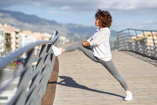 Joven mujer negra haciendo estiramiento después de correr al aire libre —  Fotos de Stock