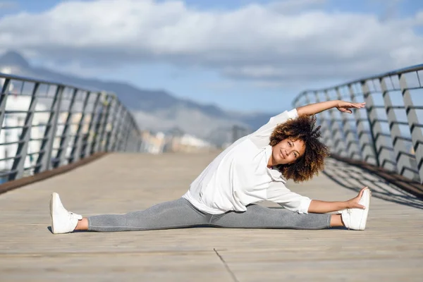 Young black woman doing stretching after running outdoors — Stock Photo, Image