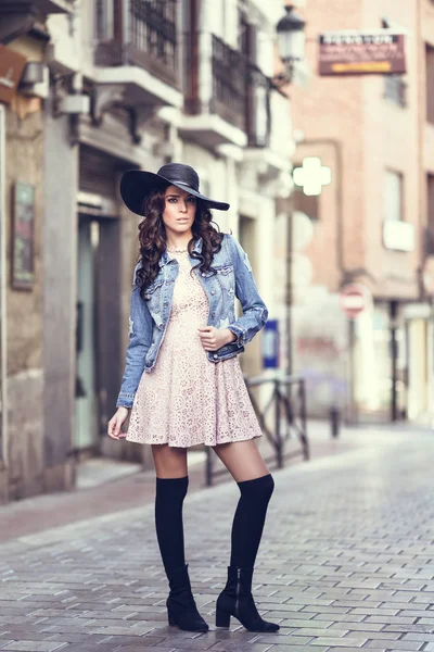 Jonge brunette vrouw stond in de stedelijke achtergrond. — Stockfoto