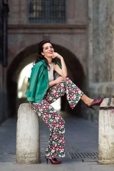 Young brunette woman smiling in urban background. — Stock Photo, Image