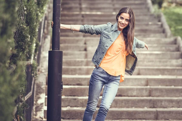 Mujer con el pelo bonito usando ropa casual en el fondo urbano . —  Fotos de Stock