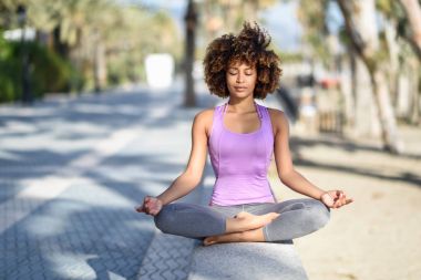 Siyah kadın, afro saç modeli, lotus asana gözleri kapalı 